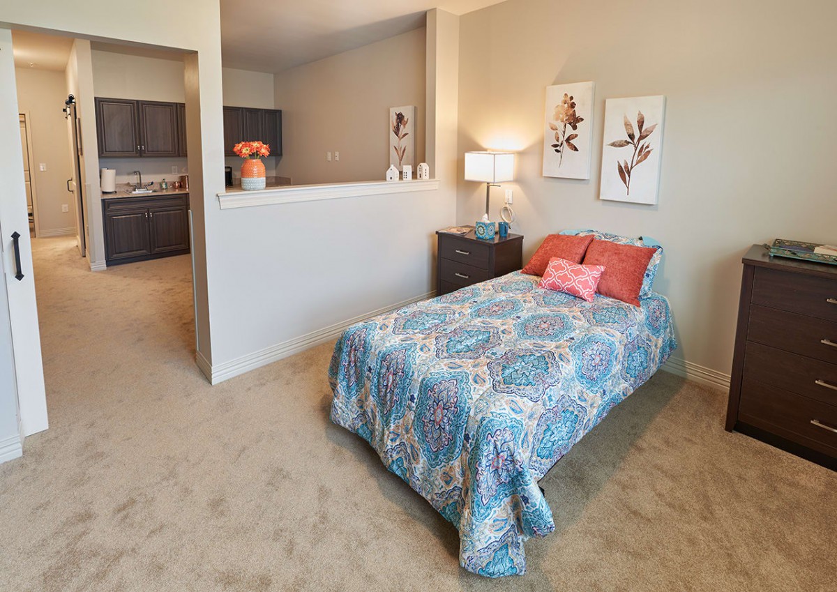 A cozy bedroom with a single bed, vibrant bedding, and stylish decor.