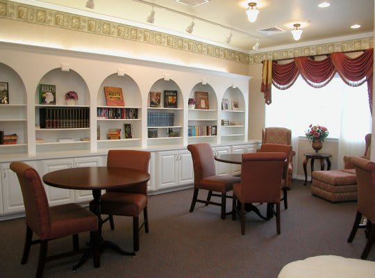 A cozy library room with bookshelves and comfortable seating.
