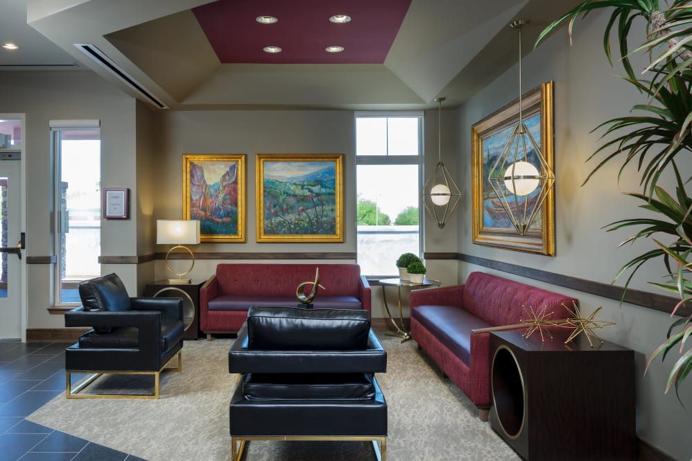 A modern living room with stylish sofas, framed artwork, and elegant lighting fixtures.