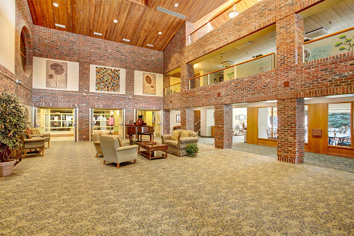 A spacious and modern lobby featuring brick walls, comfortable seating, and decorative art.