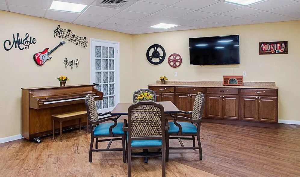 A cozy dining room with a piano, television, and decorative elements.