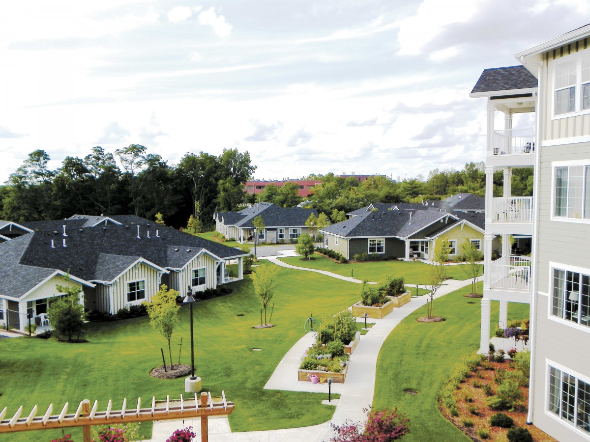 A serene residential area with neatly landscaped gardens and pathways connecting several houses.