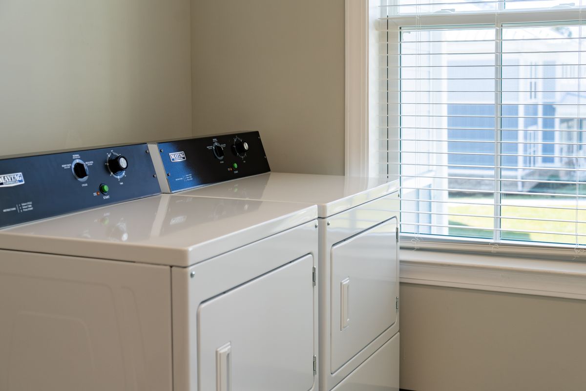 A laundry room featuring a washer and dryer next to a window.
