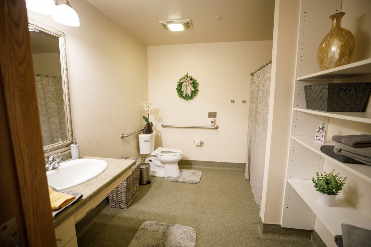 A spacious, handicap-accessible bathroom featuring a bathtub, toilet, and modern amenities.
