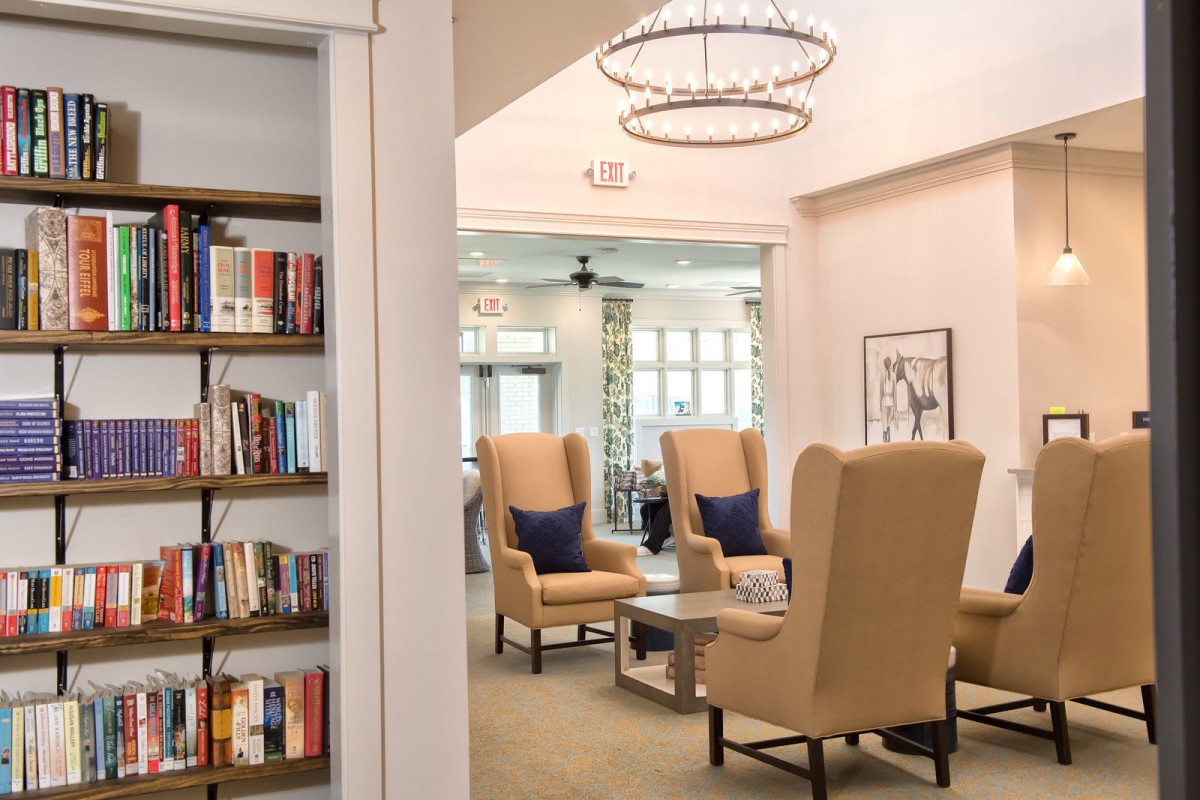 A cozy living area with comfortable chairs and a bookshelf, designed for relaxation and reading.