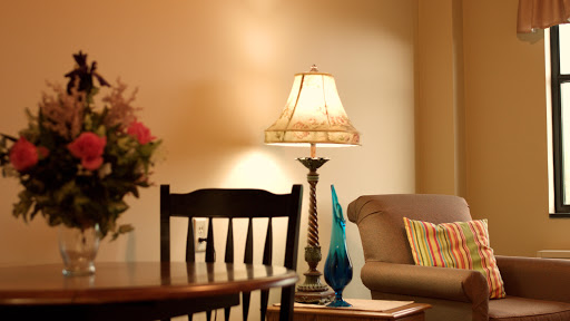 A cozy living room setup featuring a lamp, a comfortable sofa, and decorative touches.