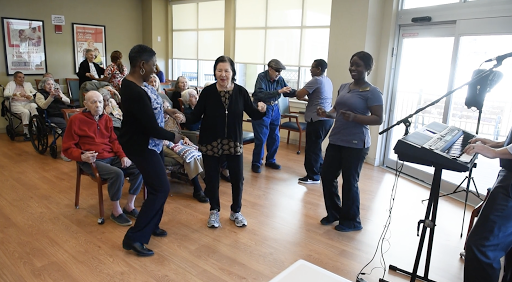 Seniors engaging in a joyful dance activity, promoting social interaction and movement.