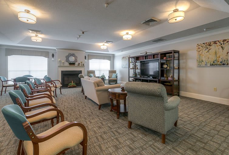 A cozy living room featuring comfortable seating, a fireplace, and a television.