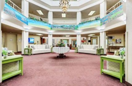 A spacious and elegantly designed lobby area with a large chandelier, comfortable sofas, and decorative elements.
