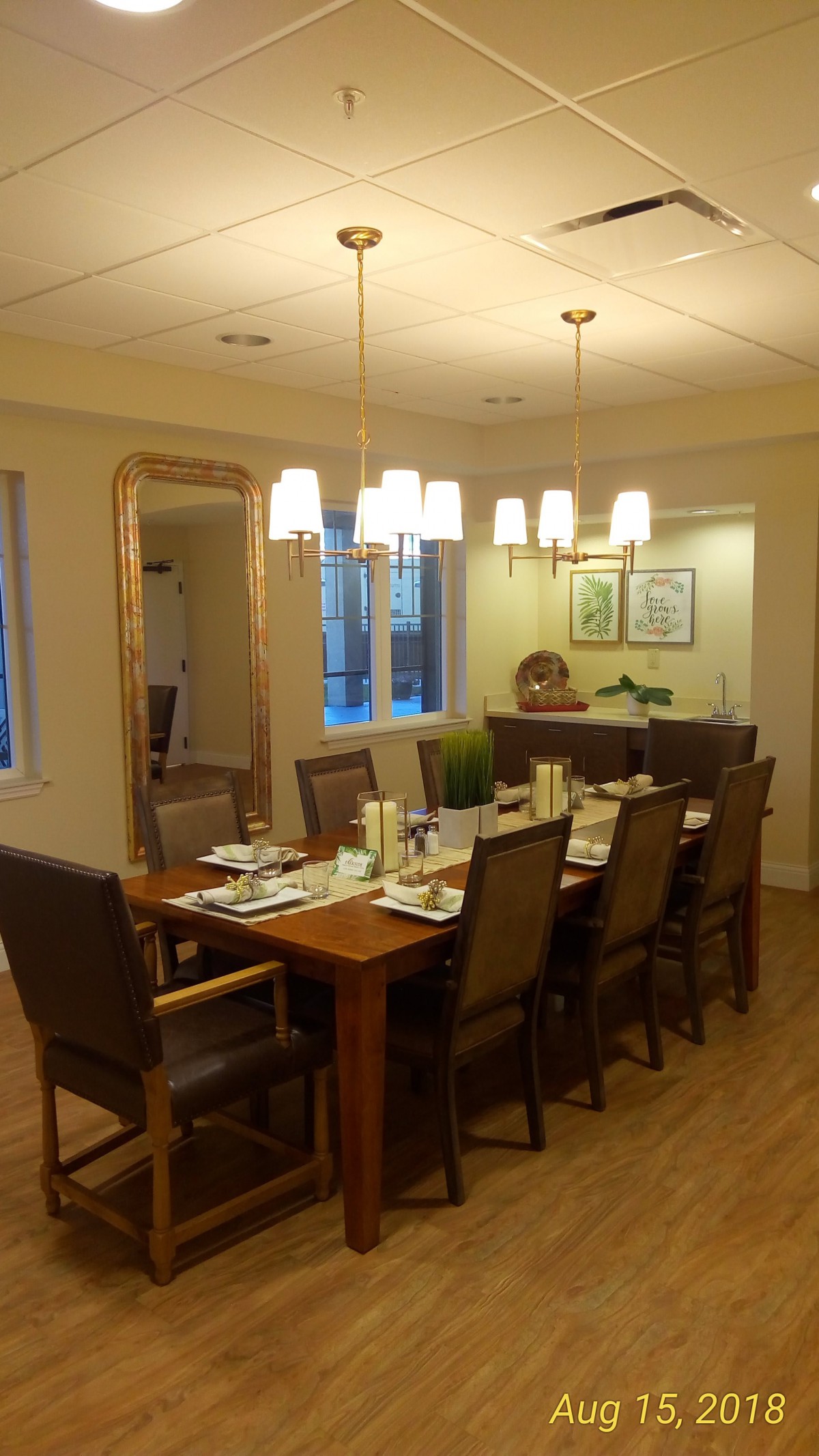 A warm and inviting dining room with a large table set for a meal, surrounded by comfortable chairs and illuminated by overhead lighting.