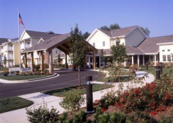 A suburban residential building with well-maintained landscaping and a driveway.