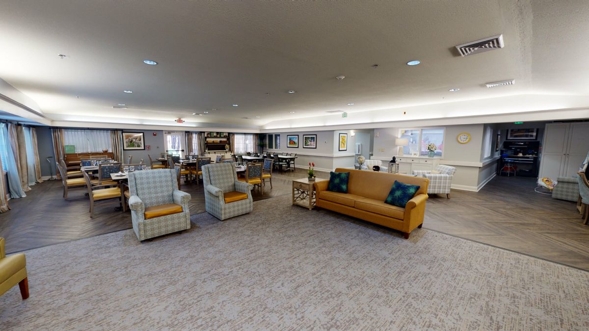 A spacious living room with comfortable seating and carpeted flooring.