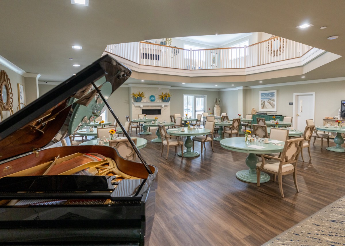 A stylish dining area featuring a grand piano and elegant decor.
