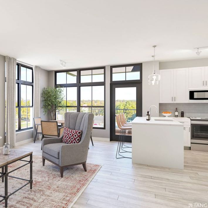 A bright and modern living space with an open floor plan featuring a kitchen island and large windows.