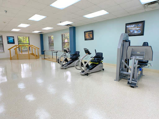 A spacious gym area featuring exercise equipment designed for fitness and rehabilitation.