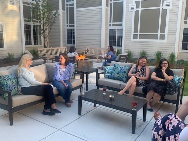 A group of people enjoying a casual conversation on a patio.