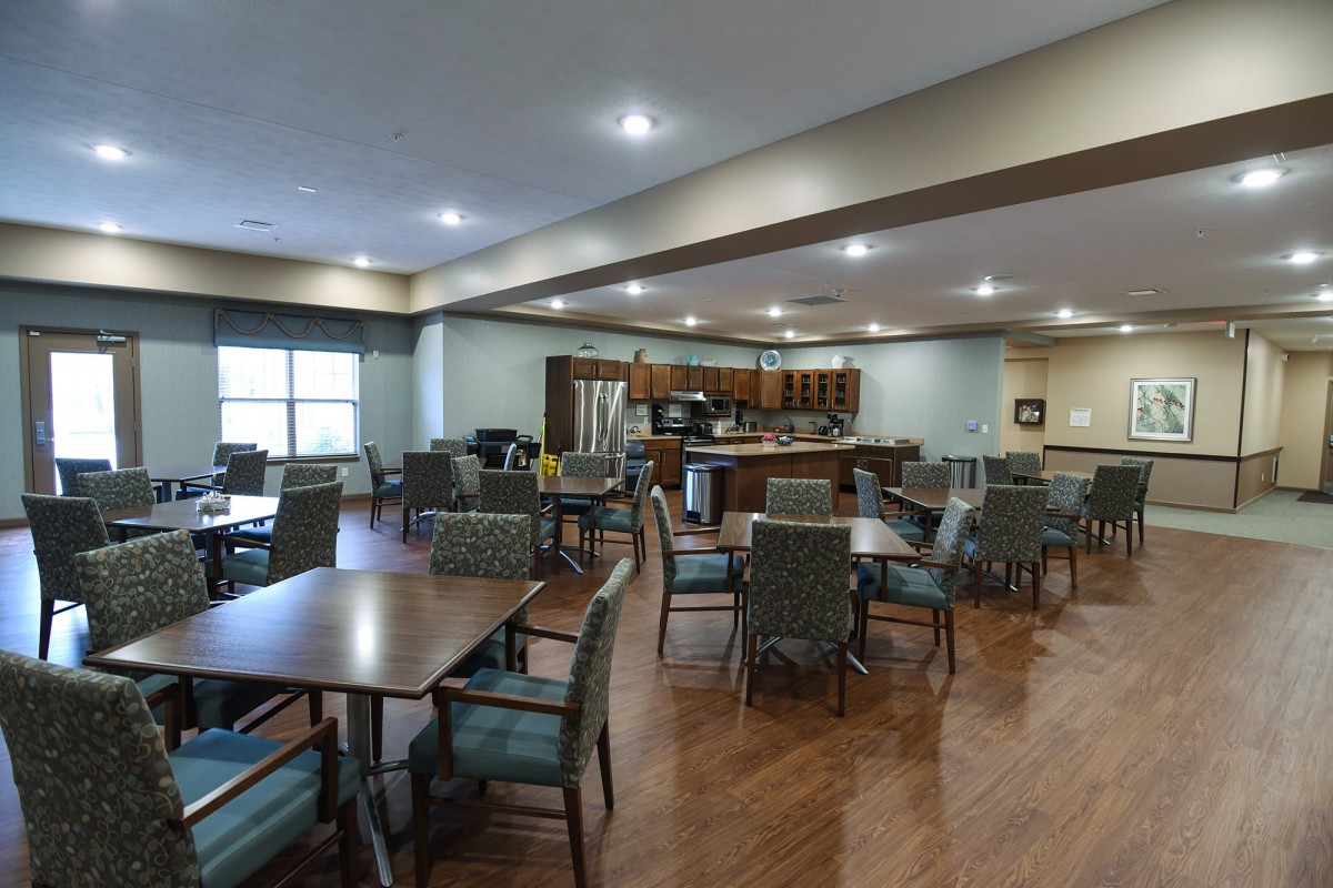 Spacious and well-lit dining area with tables and chairs arranged for communal gatherings.