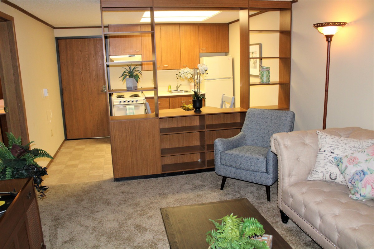 Cozy apartment living room with an open view of the kitchen and comfortable furnishings.