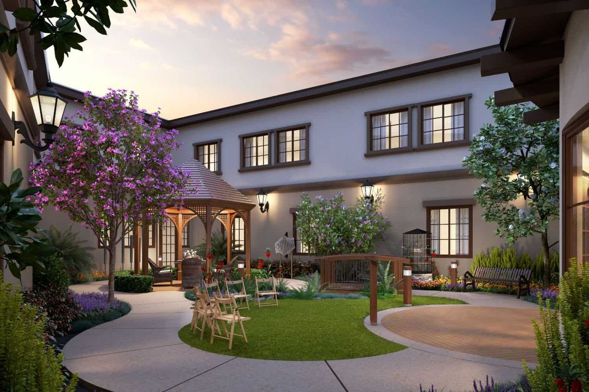 A beautiful house with a well-landscaped garden and patio area during the evening.