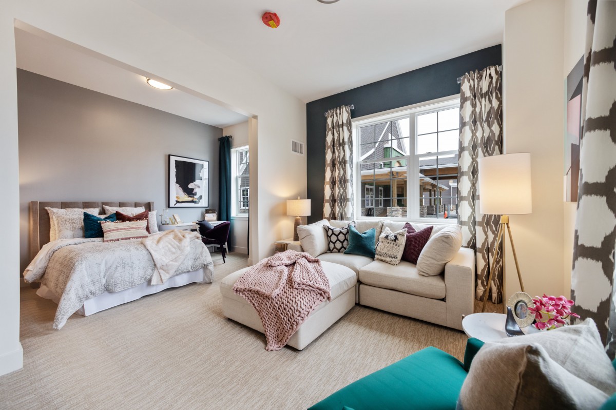 A modern bedroom with a cozy living area, featuring a comfortable sofa and stylish decor.