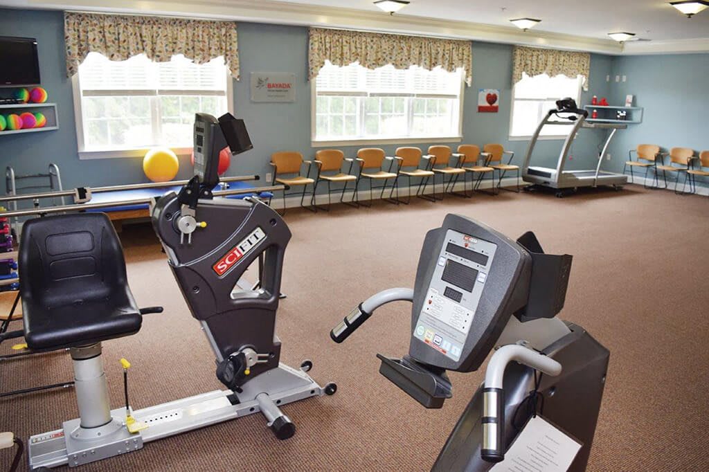 A well-equipped gym room featuring exercise machines and fitness equipment.
