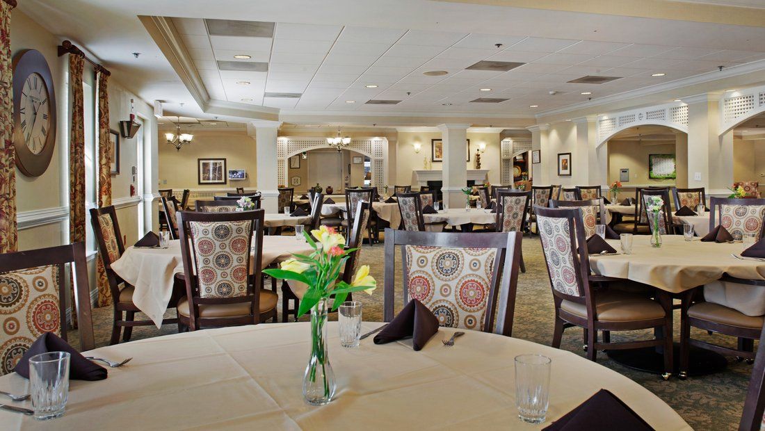 A neatly arranged restaurant dining area with elegant decor and flowers on the tables.