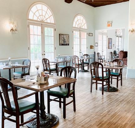 Bright and airy restaurant interior with wooden tables and chairs.