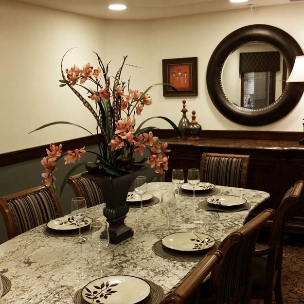 A beautifully set dining room with elegant decor and floral centerpiece.