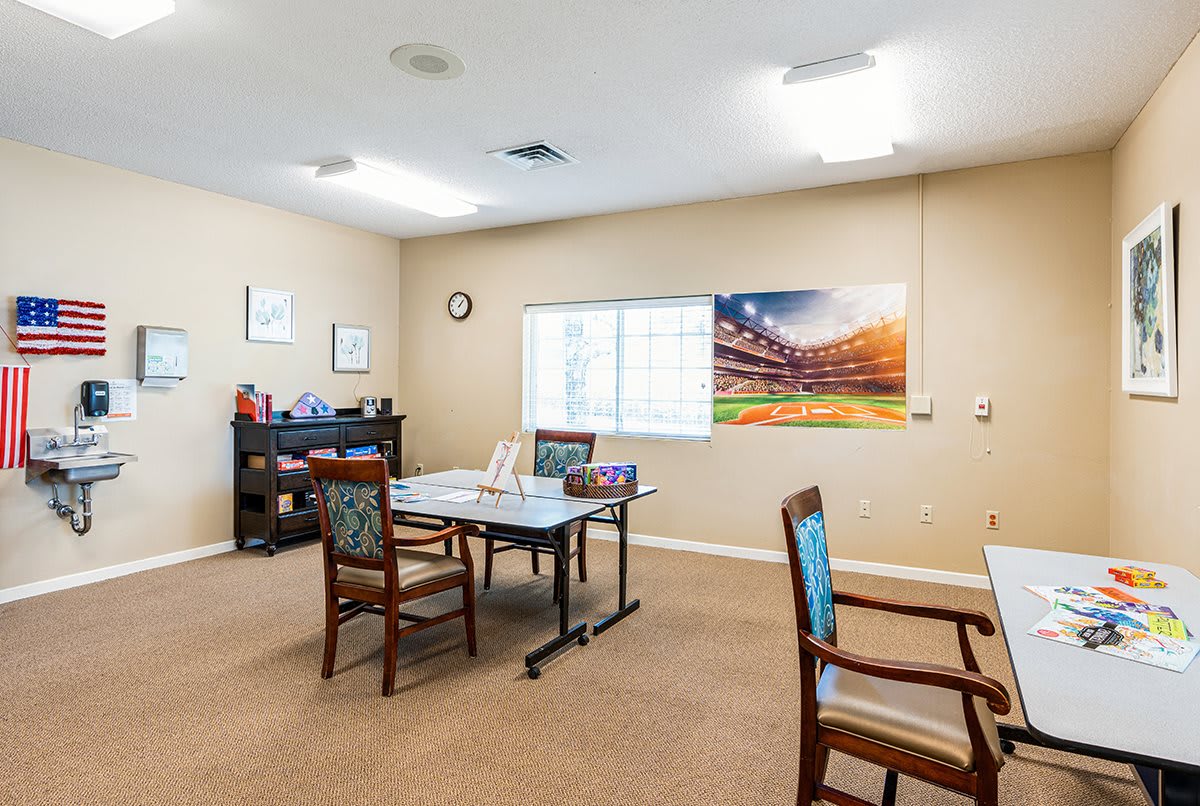A small meeting room with tables and chairs arranged for a group discussion.