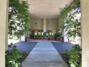 A view of a building entrance framed by lush greenery.