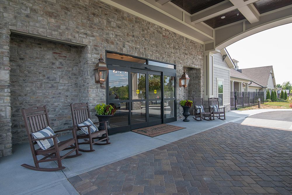 A welcoming building entrance with seating and decorative plants.
