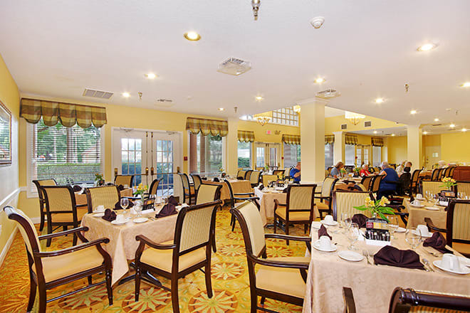 An elegant dining room setting with neatly arranged tables and chairs.