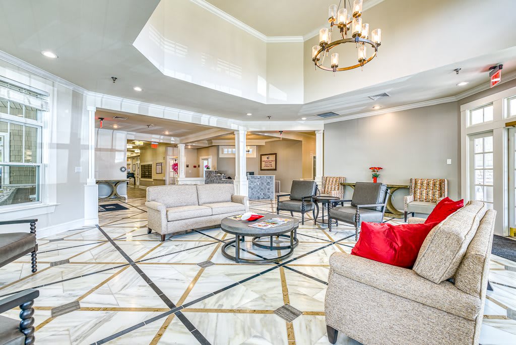 A modern hotel lobby featuring elegant furniture, a chandelier, and stylish decor.