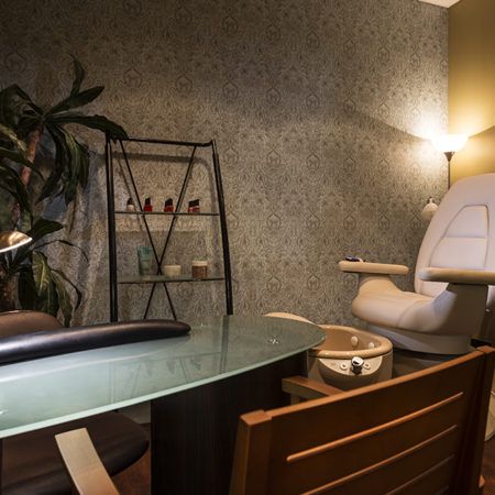 A cozy office space with a glass desk, comfortable chair, and ambient lighting.
