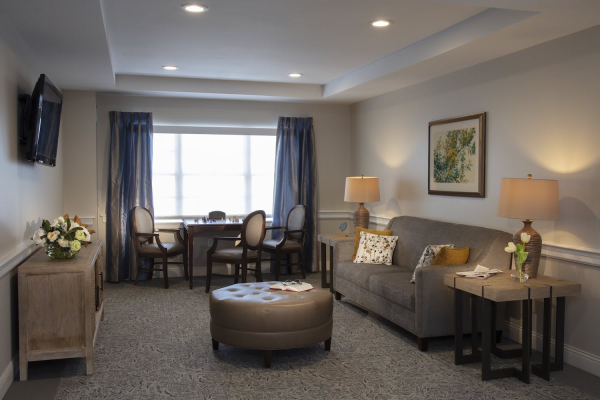 A cozy and well-decorated living room with a sofa, coffee table, and large window.