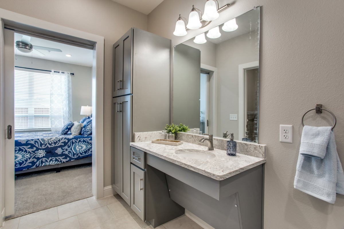 A modern bathroom featuring a sleek vanity with a large mirror and stylish lighting.