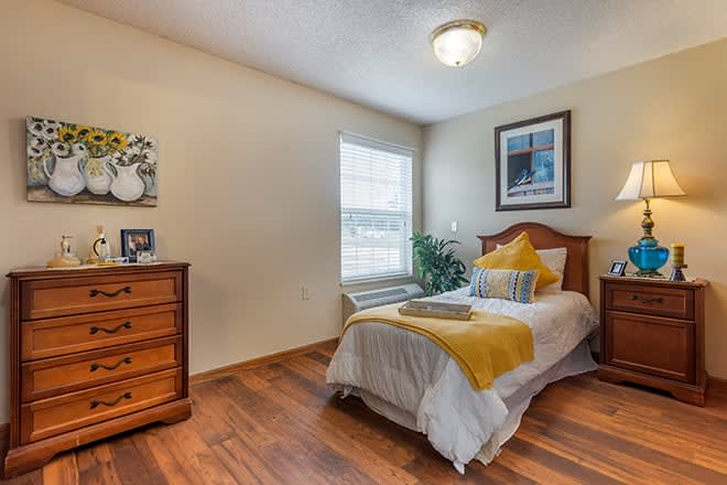 Cozy bedroom with a single bed and wooden furniture.