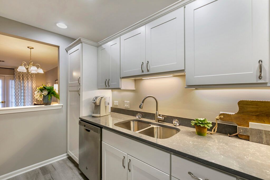 A modern kitchen with white cabinets and stainless steel appliances, showcasing a clean and minimalist design.