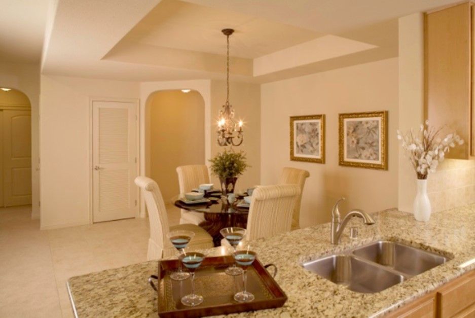 A cozy dining area adjacent to a kitchen, featuring elegant decor and ambient lighting.