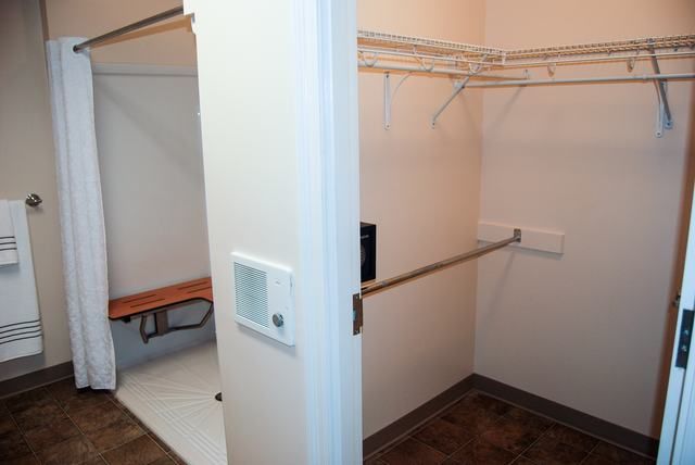 An empty walk-in closet featuring shelving and hanging rods for storage.