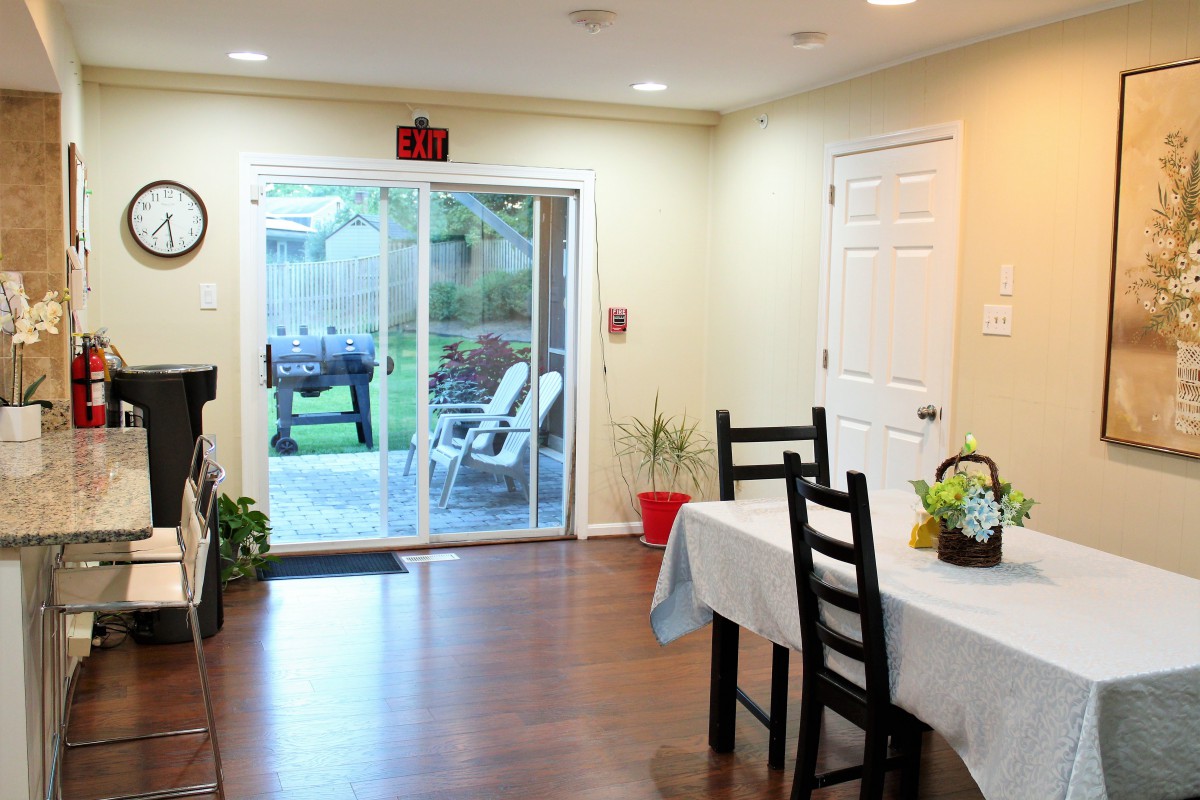 A cozy dining area with a table and chairs, leading to an outdoor patio through sliding glass doors.