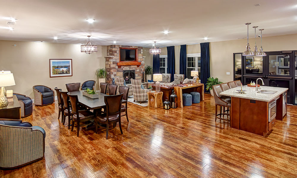 A spacious open floor plan featuring a modern living room and dining area with hardwood floors and cozy lighting.