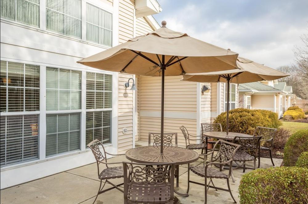 An inviting patio area featuring outdoor furniture with umbrellas, situated outside a building.