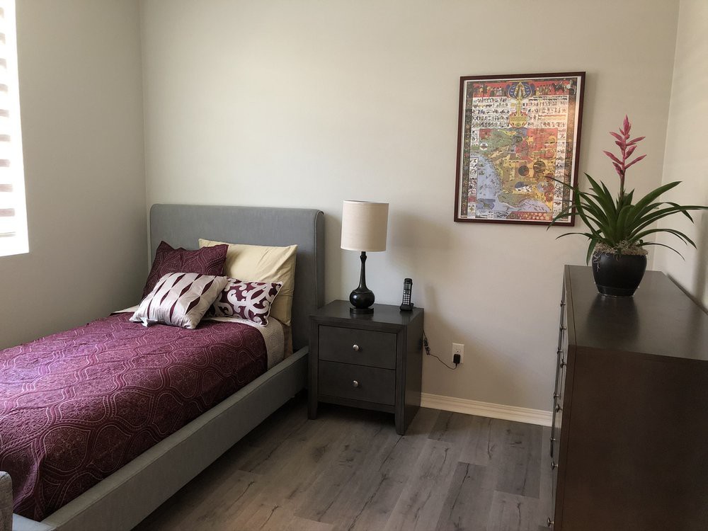 A minimalistic bedroom with a bed, nightstand, and lamp.