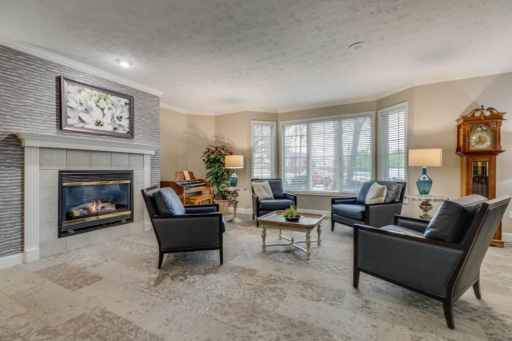A modern living room with a cozy seating arrangement and a fireplace.