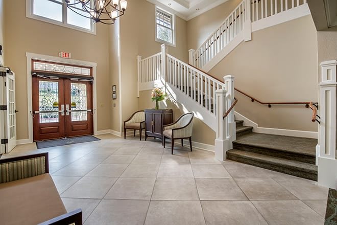 An inviting lobby area featuring a staircase, elegant furniture, and soft lighting.