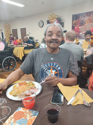 Enjoying a delicious meal with a smile in a community dining setting.