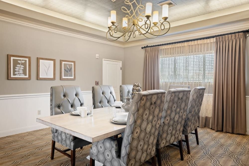 Elegant dining room with a modern chandelier and tufted chairs.