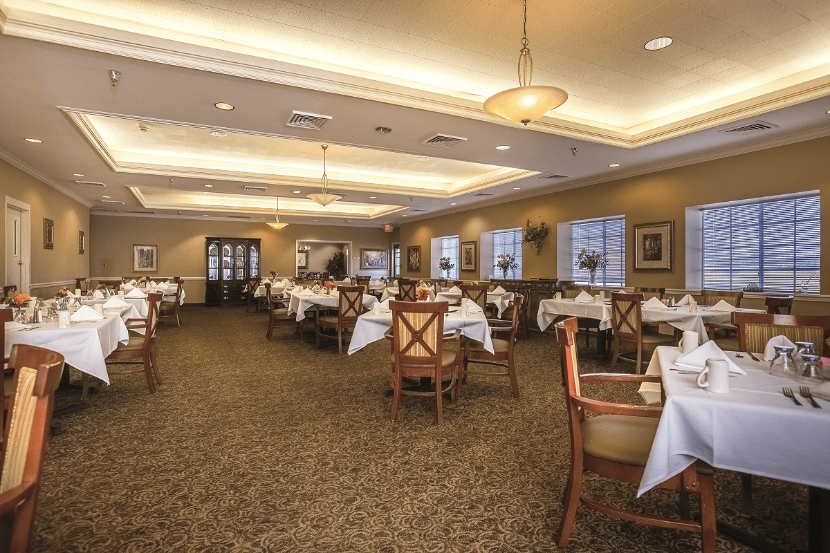An elegant restaurant dining room with neatly arranged tables and ambient lighting.