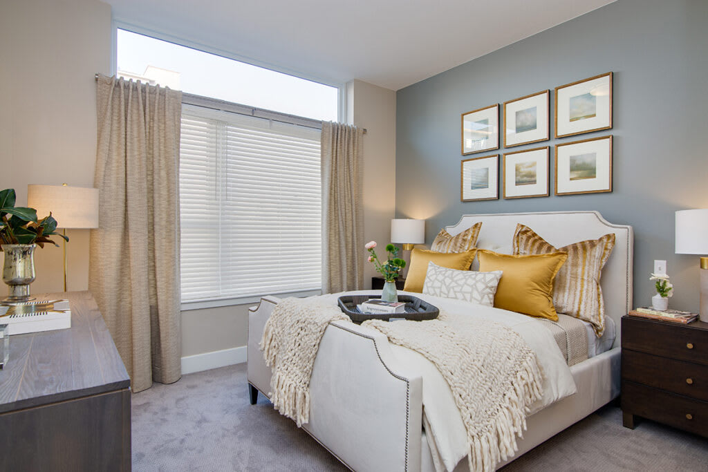 A modern and cozy bedroom featuring neutral colors with elegant bedding and wall art.